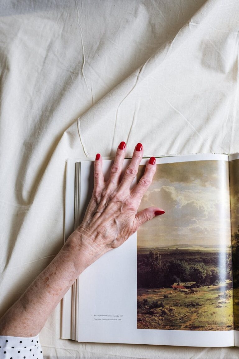 persons left hand with red manicure